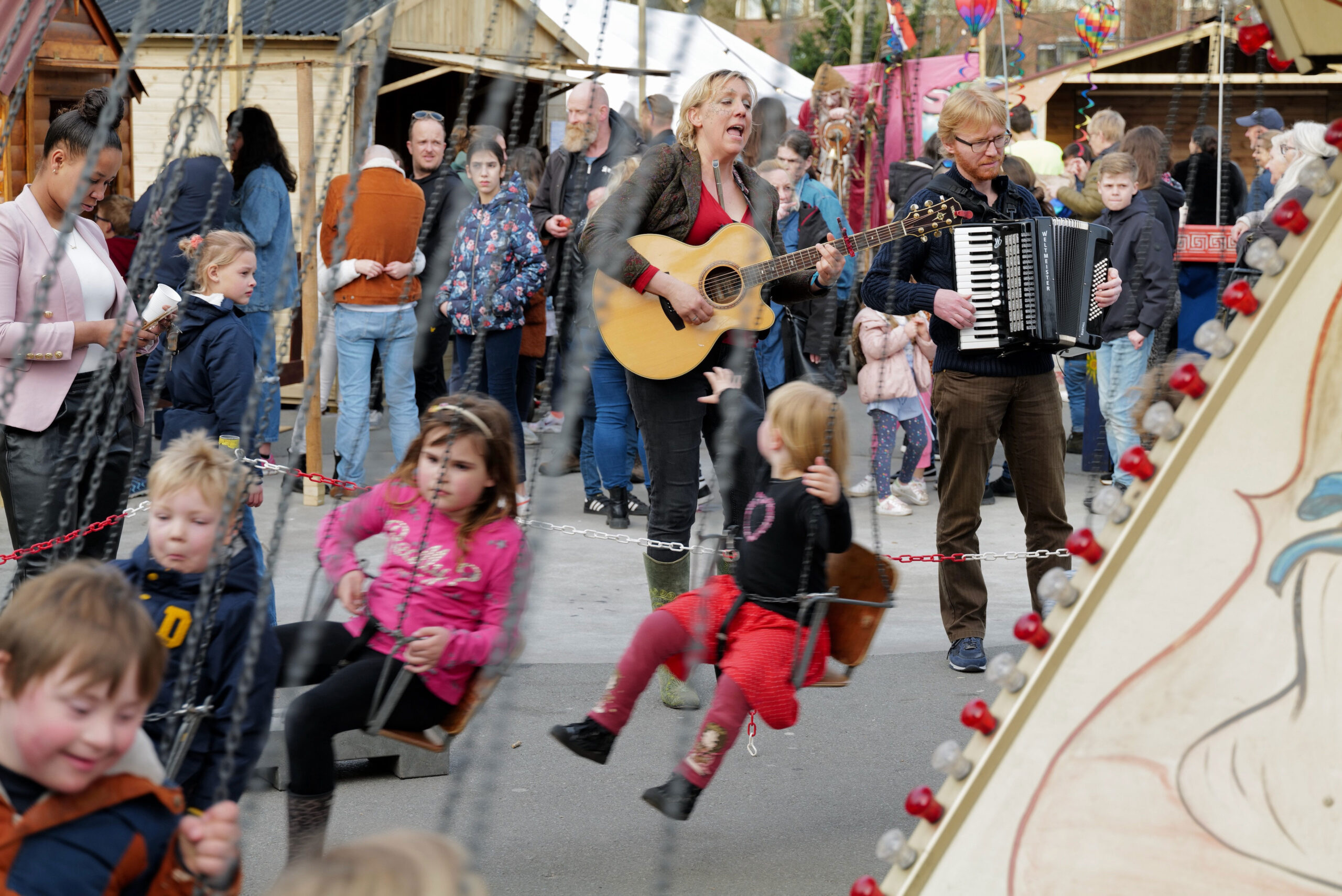 Kinderen in zweefmolen en muziek tijdens het Lentefestival Oosterparkwijk